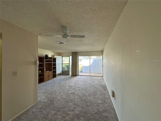 carpeted spare room with ceiling fan and a textured ceiling