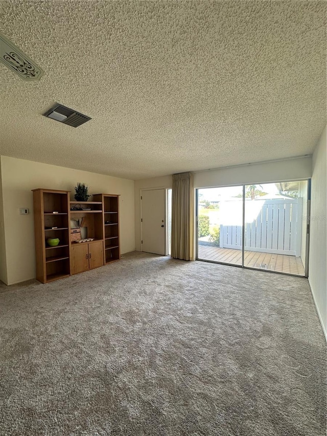 unfurnished living room with carpet floors and a textured ceiling