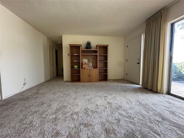 unfurnished living room with carpet floors and a textured ceiling