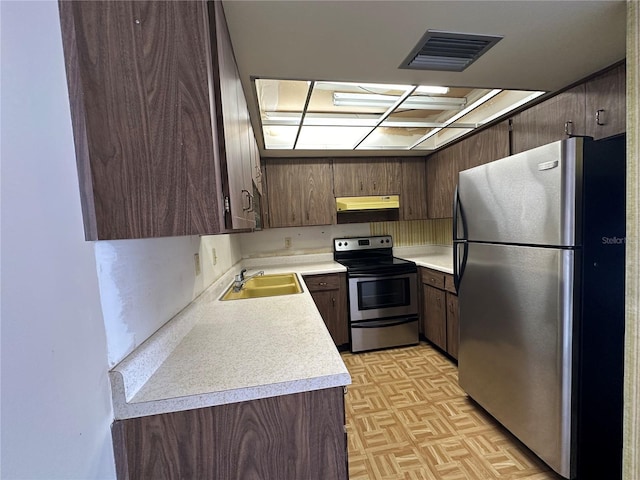 kitchen with sink, dark brown cabinets, stainless steel appliances, and light parquet flooring