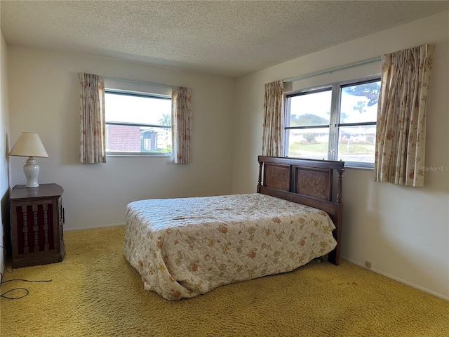 carpeted bedroom featuring multiple windows and a textured ceiling