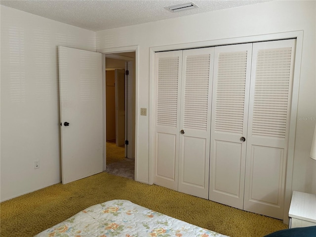 unfurnished bedroom with light colored carpet, a textured ceiling, and a closet