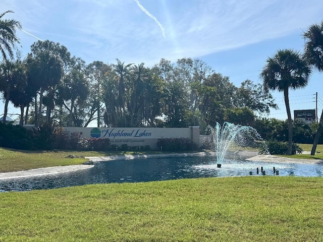 view of property's community with a water view and a yard