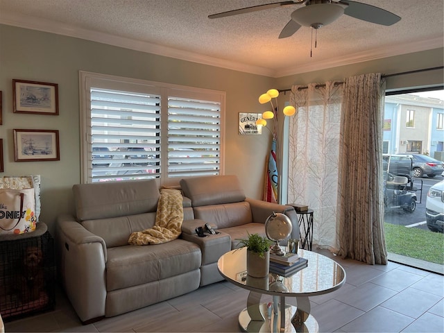 living room with ornamental molding, ceiling fan, and a textured ceiling