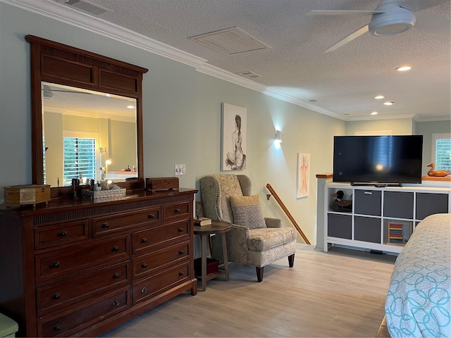 bedroom featuring ornamental molding, light hardwood / wood-style floors, and a textured ceiling