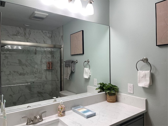 bathroom featuring vanity, toilet, and an enclosed shower