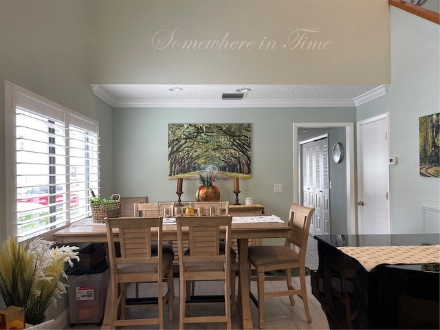 tiled dining space featuring crown molding