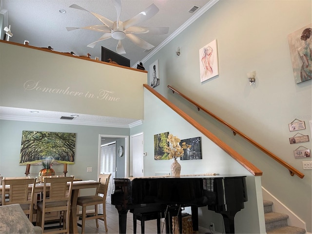 misc room with tile patterned flooring, crown molding, ceiling fan, and high vaulted ceiling