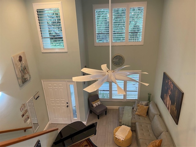 living room featuring a towering ceiling and light wood-type flooring