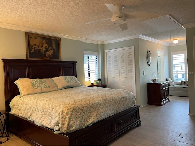 bedroom featuring crown molding, a textured ceiling, light wood-type flooring, and a closet