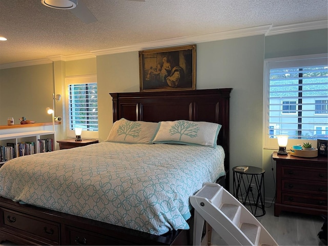 bedroom with ornamental molding, light wood-type flooring, and a textured ceiling