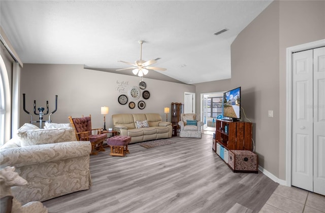 living room featuring ceiling fan, vaulted ceiling, and light wood-type flooring