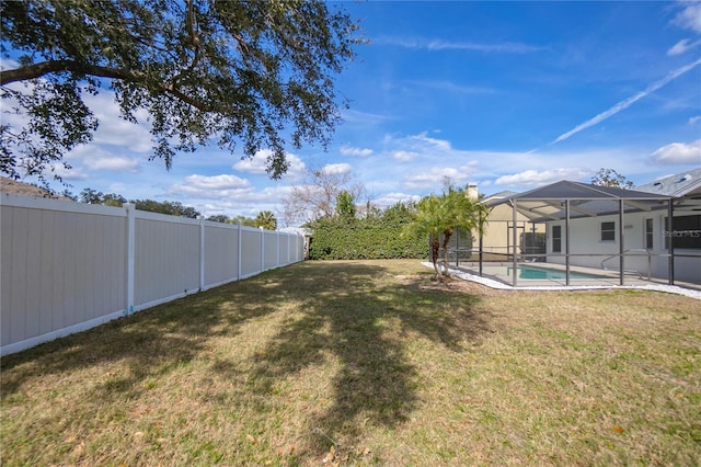 view of yard featuring a fenced in pool and glass enclosure