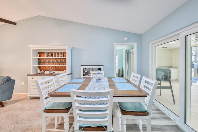 dining area featuring carpet flooring and vaulted ceiling