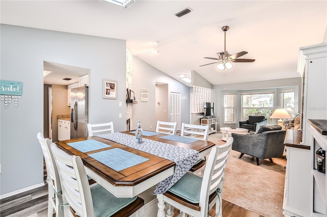 dining space featuring dark wood-type flooring, ceiling fan, and vaulted ceiling