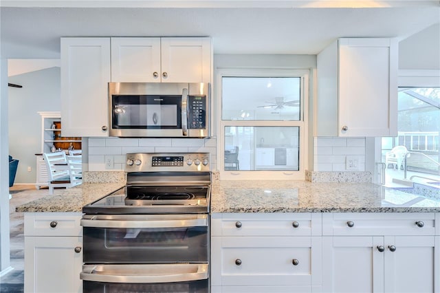 kitchen featuring backsplash, appliances with stainless steel finishes, and white cabinets