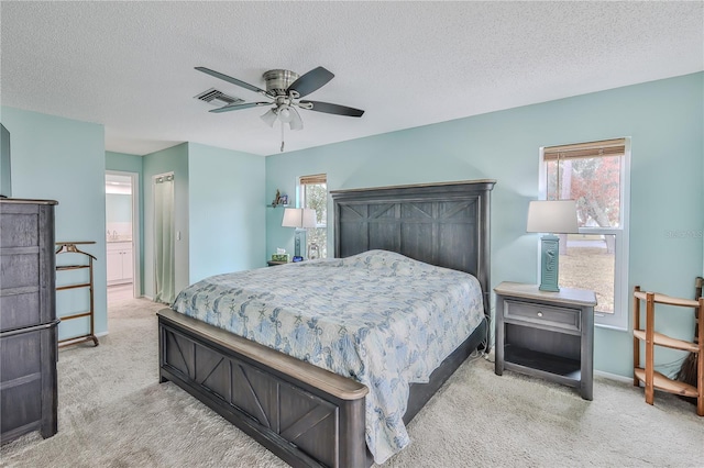 bedroom featuring ceiling fan, light colored carpet, connected bathroom, and multiple windows