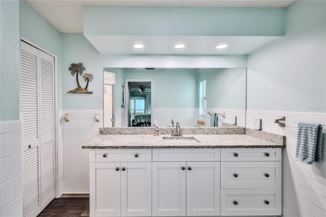 bathroom featuring tile walls, vanity, and hardwood / wood-style floors