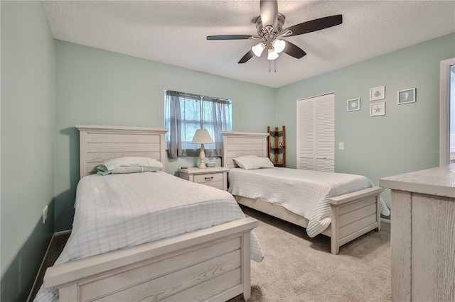 carpeted bedroom featuring ceiling fan, a closet, and a textured ceiling