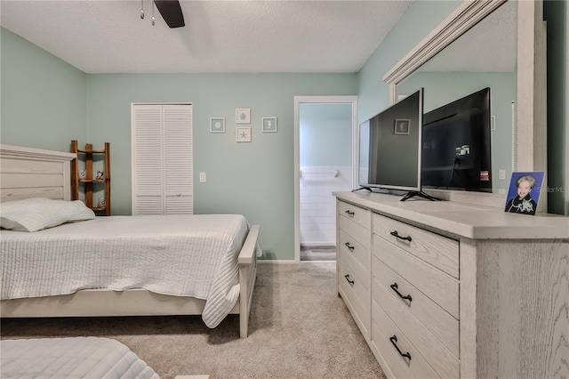 bedroom with light carpet, ceiling fan, a closet, and a textured ceiling