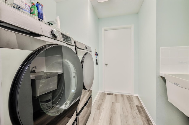 laundry room featuring light hardwood / wood-style flooring and washing machine and dryer