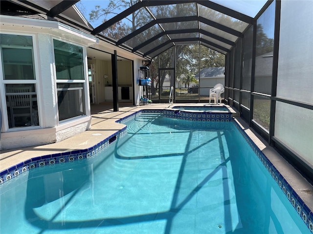 view of swimming pool featuring an in ground hot tub, a patio area, and glass enclosure