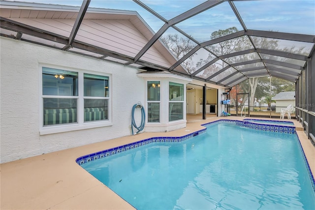 view of swimming pool featuring an in ground hot tub, a patio, and glass enclosure