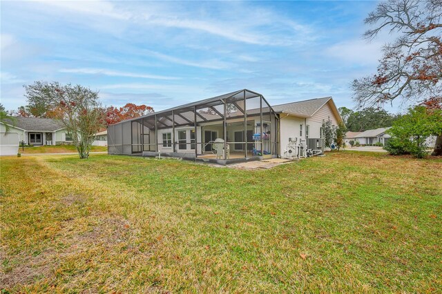 back of house with central AC, a yard, a lanai, and a patio