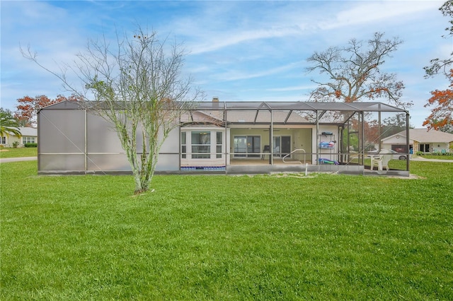 back of property with a lanai and a lawn