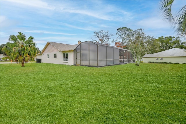 rear view of property with a yard and central air condition unit