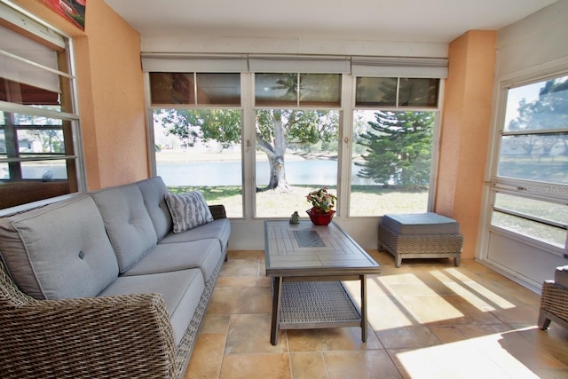 sunroom featuring a wealth of natural light and a water view