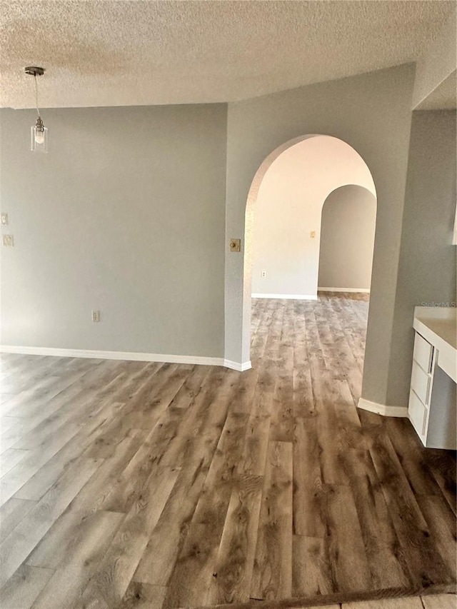 unfurnished room featuring wood-type flooring and a textured ceiling