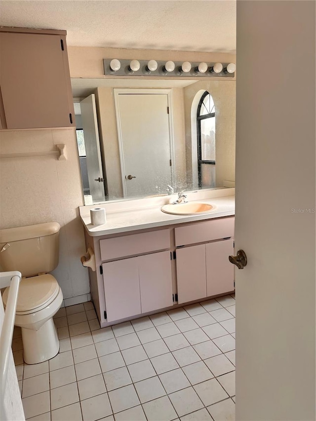 bathroom featuring vanity, tile patterned floors, and toilet