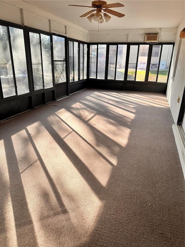 unfurnished sunroom featuring a wall mounted AC and ceiling fan