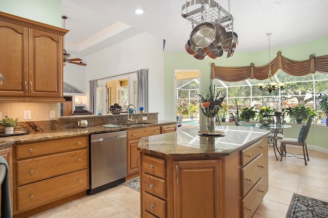 kitchen featuring sink, dishwasher, stone counters, tasteful backsplash, and a kitchen island