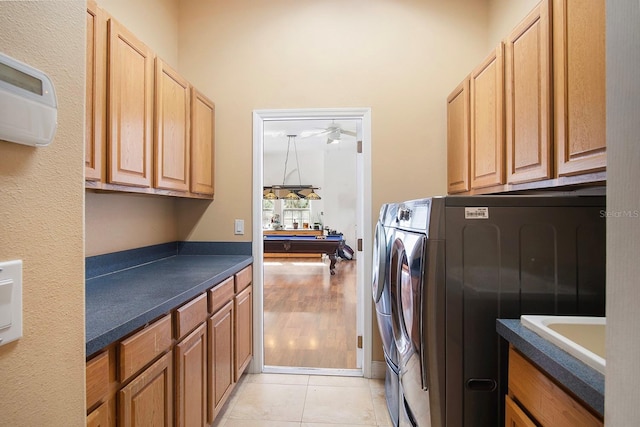 clothes washing area featuring light tile patterned floors, sink, washer and clothes dryer, billiards, and cabinets