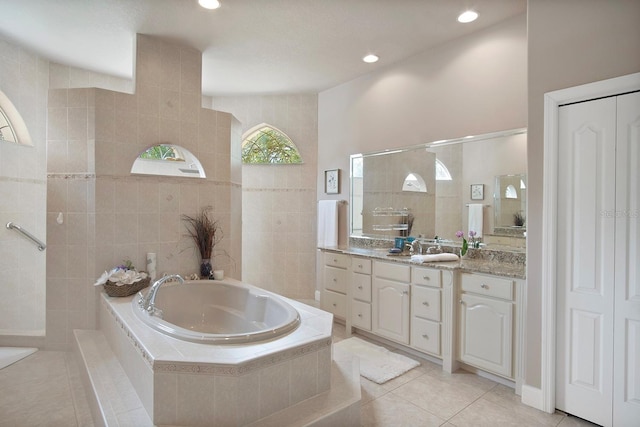 bathroom featuring vanity, separate shower and tub, tile patterned flooring, and tile walls