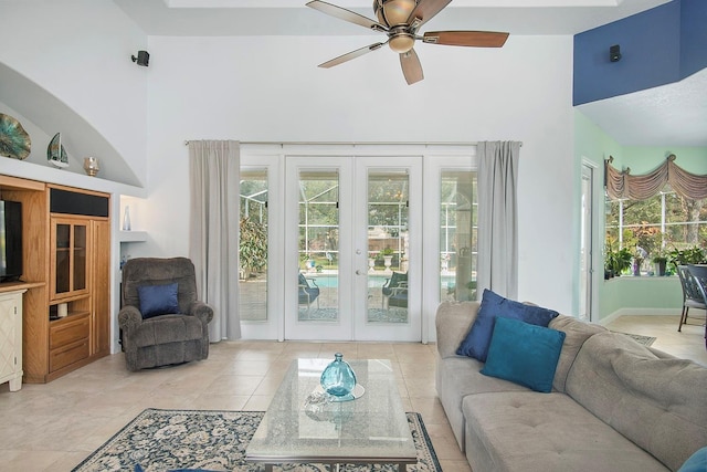 living room featuring french doors, ceiling fan, built in features, and a high ceiling