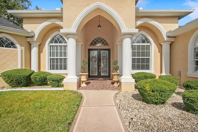 entrance to property with a lawn and french doors