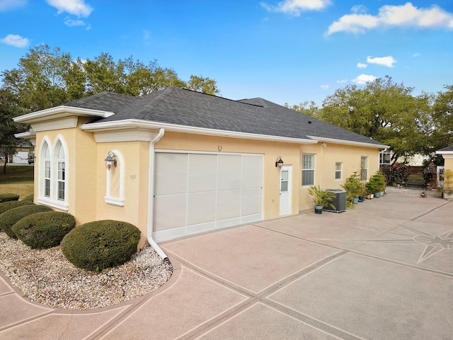 view of property exterior featuring cooling unit and a garage