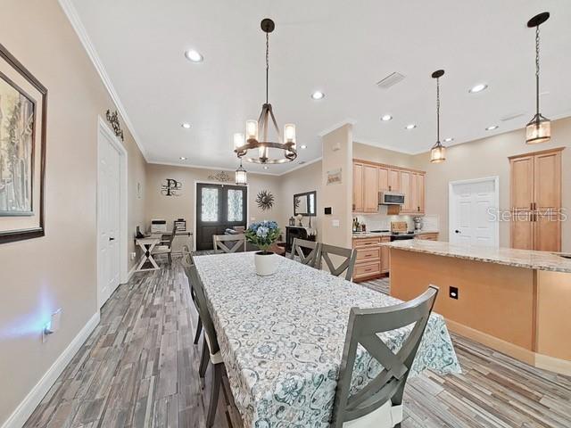 dining room with a notable chandelier, wood-type flooring, and ornamental molding