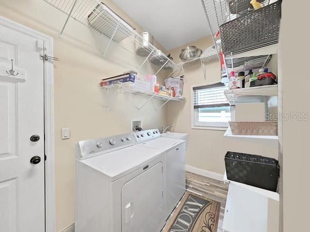 washroom with wood-type flooring and washer and clothes dryer