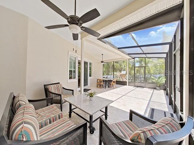 view of patio with outdoor lounge area, ceiling fan, and a lanai