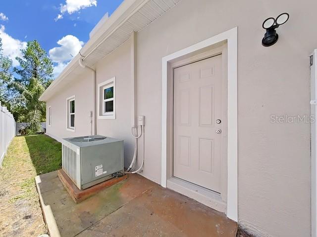 property entrance featuring central AC unit and a patio area