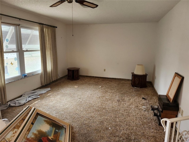 empty room with ceiling fan and a textured ceiling