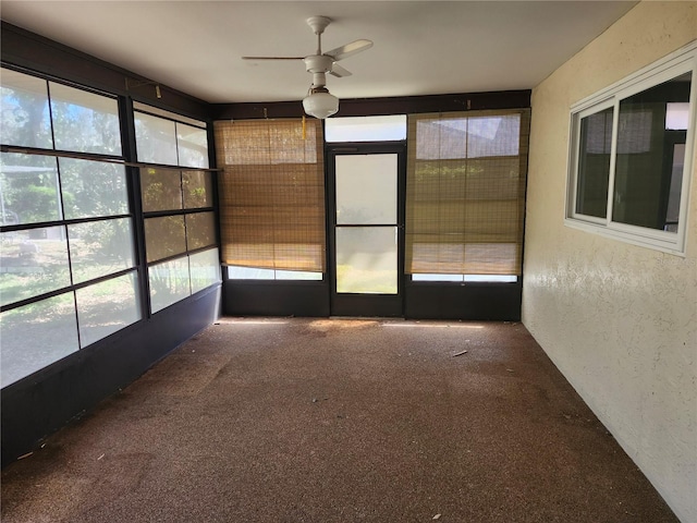 unfurnished sunroom featuring a ceiling fan