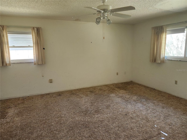 carpeted spare room featuring a ceiling fan and a textured ceiling