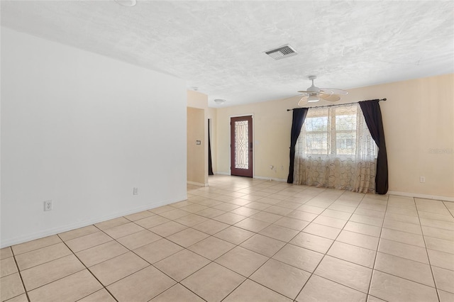 tiled spare room featuring ceiling fan and a textured ceiling