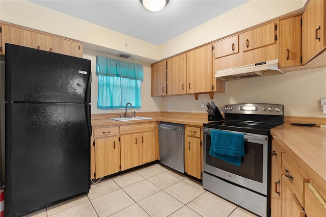 kitchen featuring light brown cabinetry, sink, light tile patterned floors, and stainless steel appliances