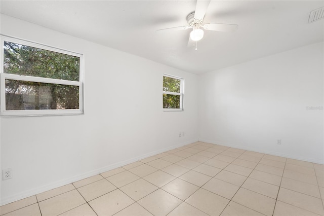 empty room with ceiling fan and light tile patterned flooring